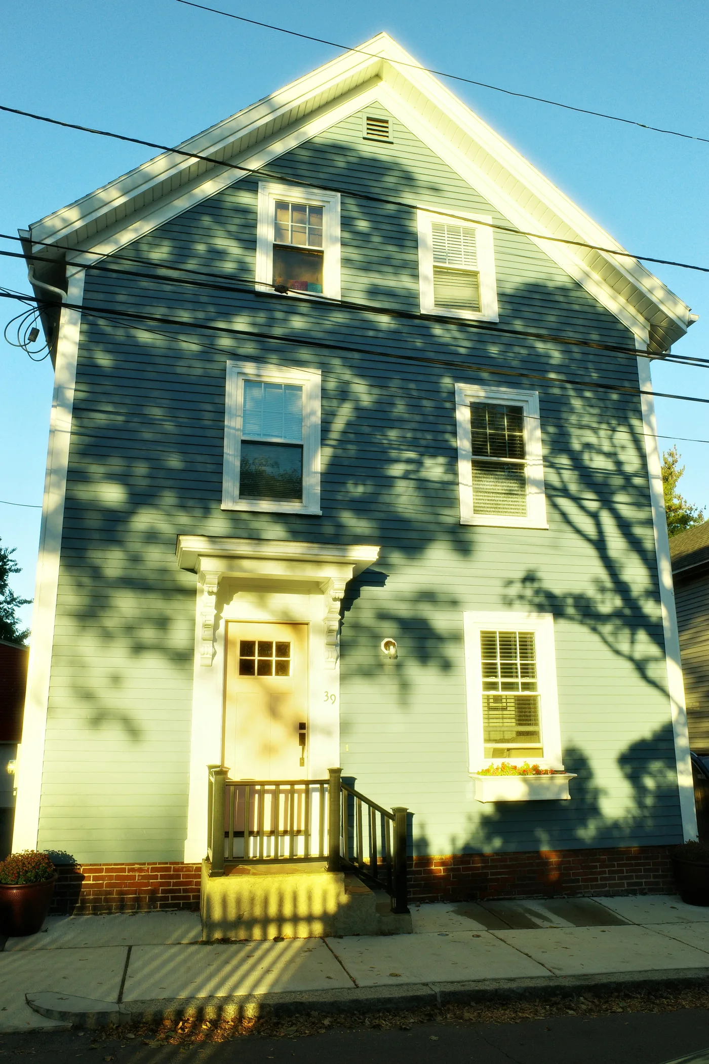 A three-storey clapboard colonial on a New England street